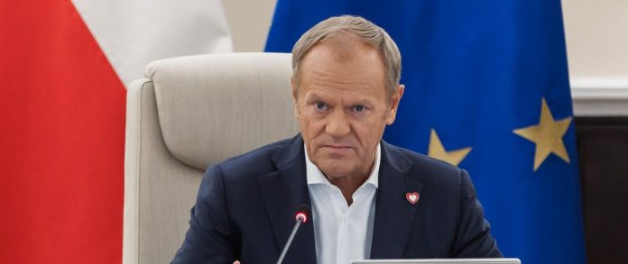 premier donald tusk na posiedzeniu rządu w tle flagi UE i Polski