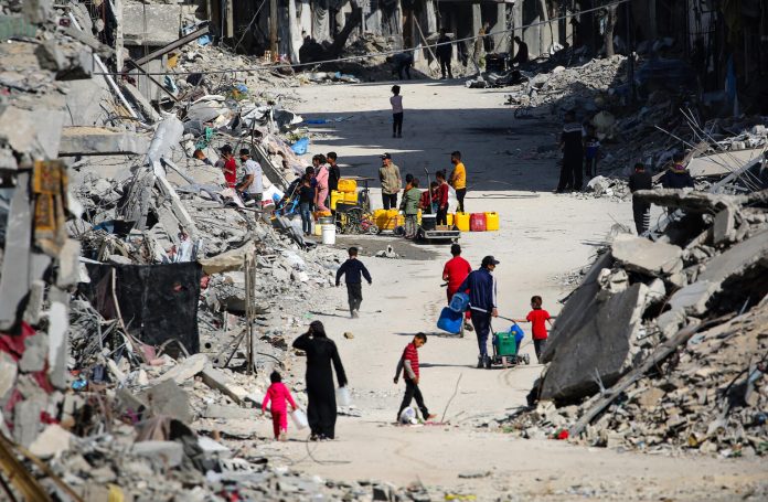 Among the rubble, Children collecting water in Khan Younis city, southern the Gaza Strip. Most of the Gaza Strip’s water systems are heavily impacted and/or non-operational due to lack of fuel, security situation and damage to production, treatment, and distribution infrastructure.